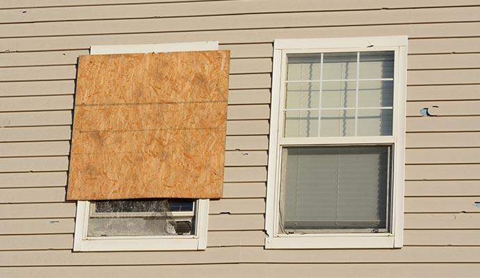 Storm-damaged windows are boarded up.