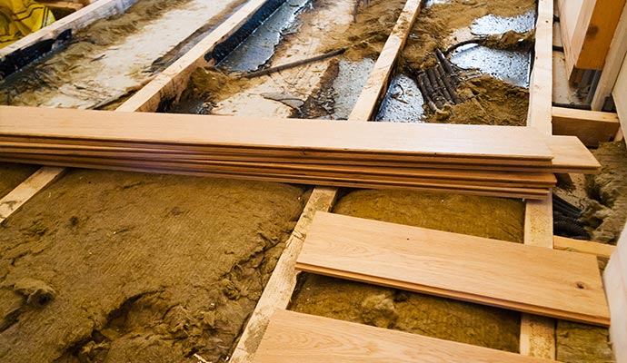 The water-damaged wooden floor is being repaired